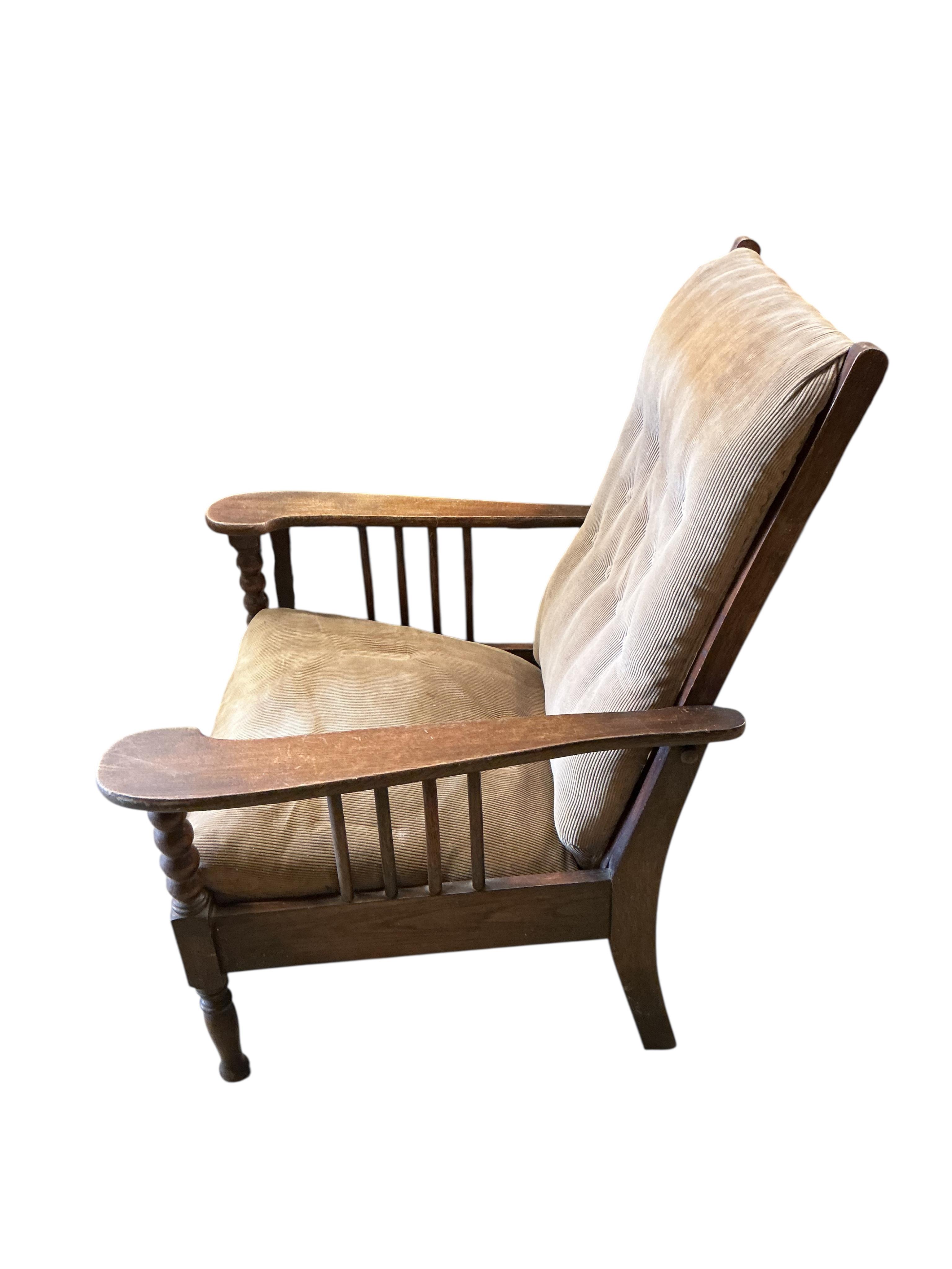 A pair of Liberty style Arts and Crafts oak reclining armchairs and an oak octagonal occasional table